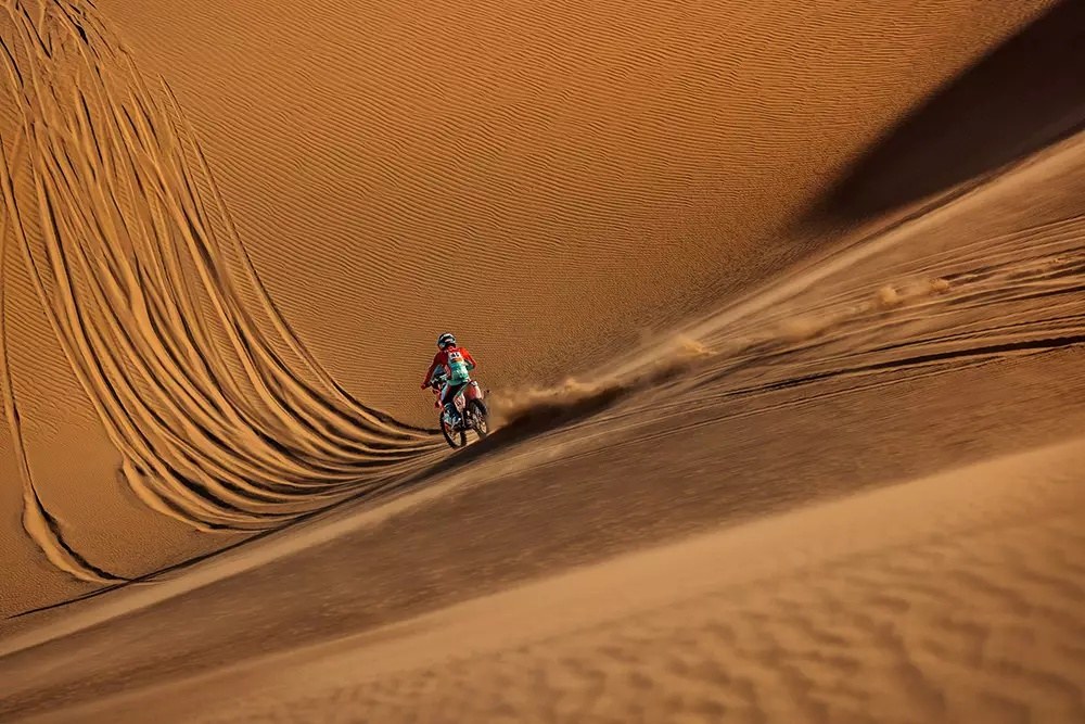 Motorcycle navigating a deep sand dune line